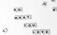 Scrabble tiles spelling 'Do What You Love' on a white background, encouraging creativity.